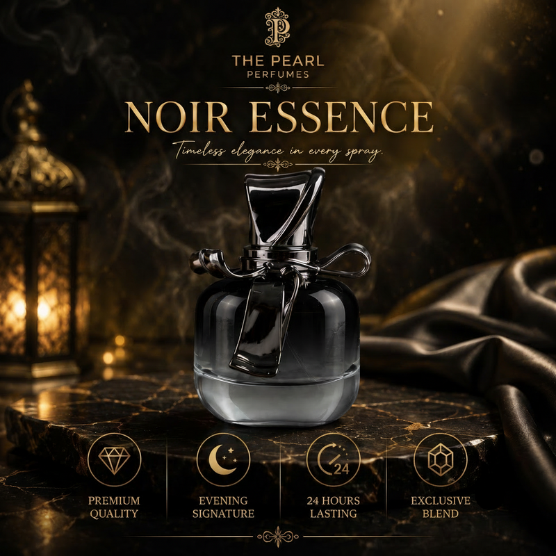 A bottle of Noir Essence perfume by The Pearl Perfumes, featuring a dark glass bottle with a black cap and silver bow, set on a dark marble surface with draped satin and a lantern in the background.
